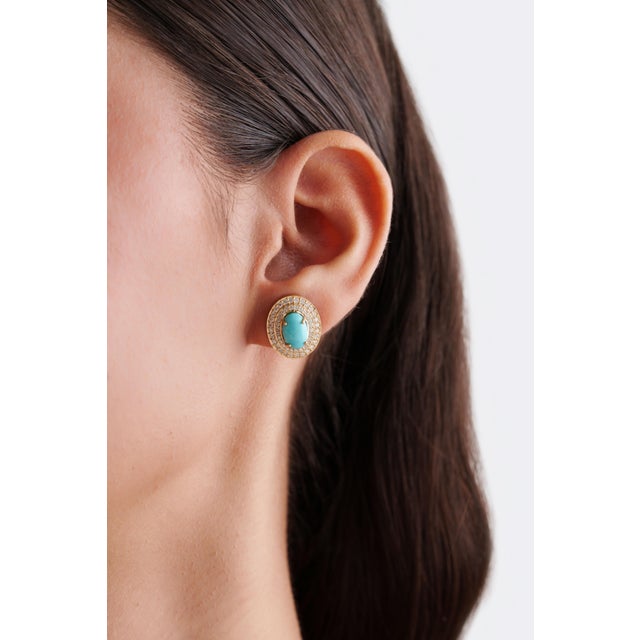 These bold stud earrings feature 3.97 carats of oval cut turquoise and diamond, set in 14K yellow gold. Each center stone...