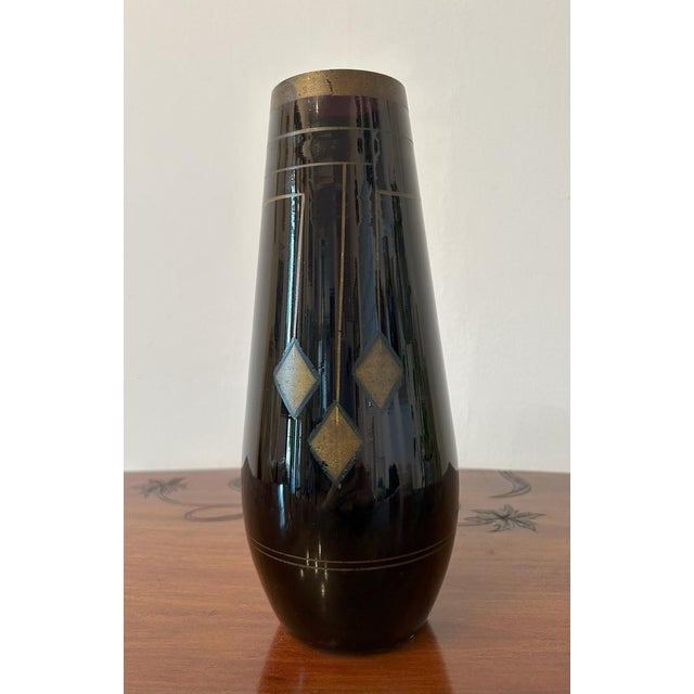 Black blown glass vase with dark amethyst highlights, decorated with gold-colored Jugendstil geometric motifs. Early 20th...