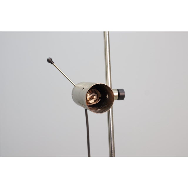 Pair of floor lamps by Tito Agnoli for Oluce (Model No. 387), made of nickel-plated metal with a travertine base. Tito...