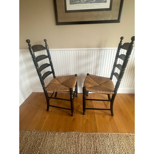 Pair of ladderback chairs made by the Hitchcock company. Featuring a painted fruit motif on the top rung and geometric...
