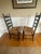 Pair of ladderback chairs made by the Hitchcock company. Featuring a painted fruit motif on the top rung and geometric...