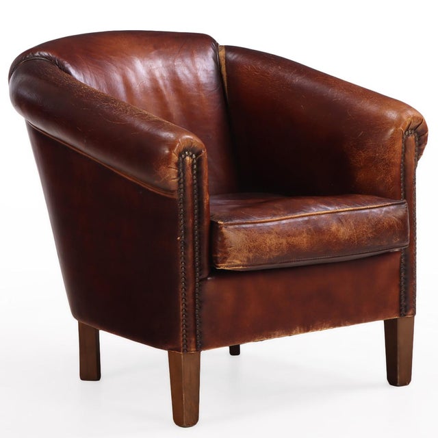 This leather club chair speaks luxury! With its rounded back and rolled arms with decorative nails, this chair has...