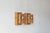A pair of wall sconces with a geometric, architectural design, crafted from solid pine with a warm, honey-amber hue. The...