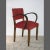 This Art Deco style chair features two arcuate armrests and its original red upholstery. It was manufactured in Germany...