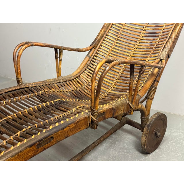 Set of two movable bamboo and rattan garden lounge chairs with wooden wheels, inspired by Italian Riviera leisure...