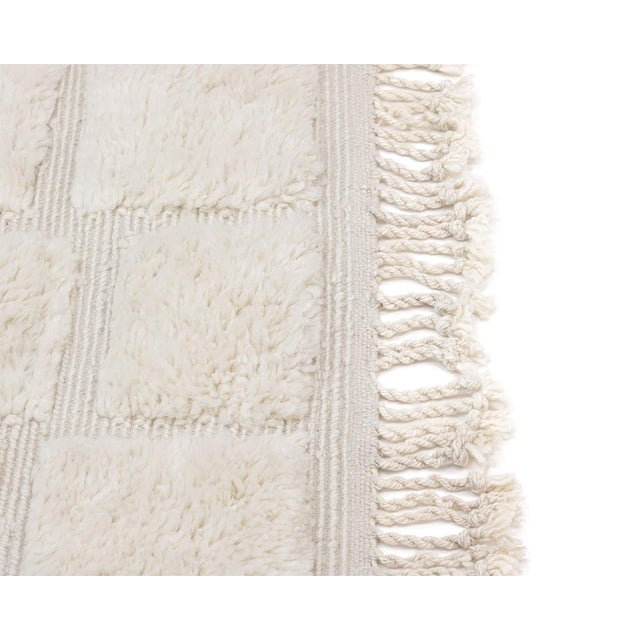 Minimalist hand-knotted wool rug with a textured checkerboard pattern in Ivory tones, offering a plush feel and a refined...