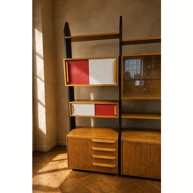 A large vintage modular wall unit with a strong architectural presence and a flexible storage layout. The contrast between...