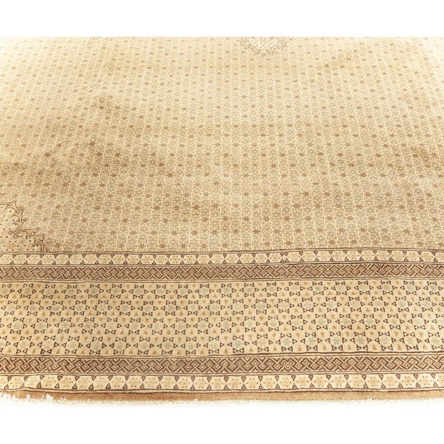 This circa-1920 Antique Tabriz rug features a large diamond medallion framed by ornate curvilinear leafy vines against a...