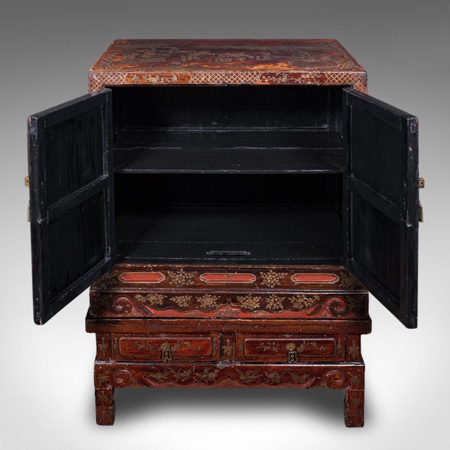 This is an antique campaign cabinet on stand. An Oriental, lacquered canvas over pine Chinoiserie cupboard, dating to the...