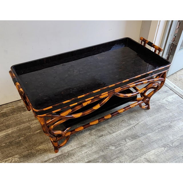 Enhance your space with this striking vintage Chinoiserie style two-tier tray-top coffee table, beautifully capturing the...