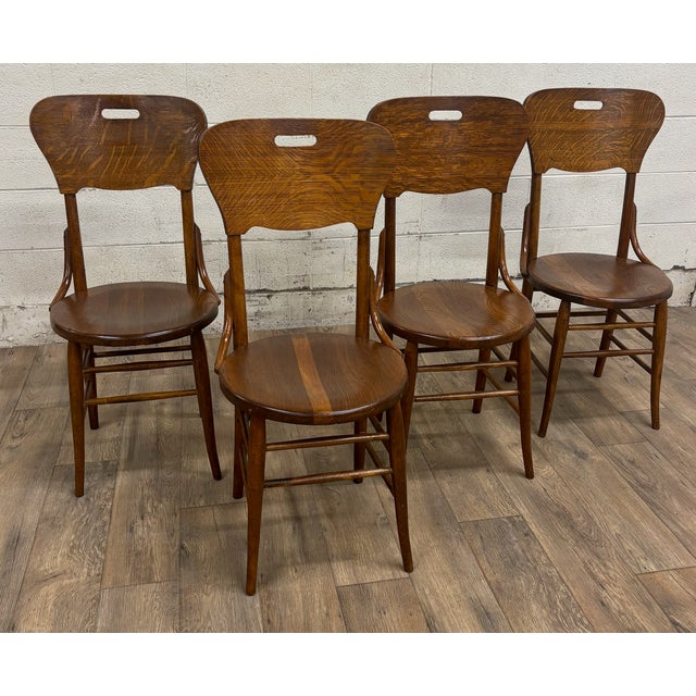 This is a stunning and rare full set of four antique Art Deco style tiger oak bentwood bistro dining chairs. They feature...