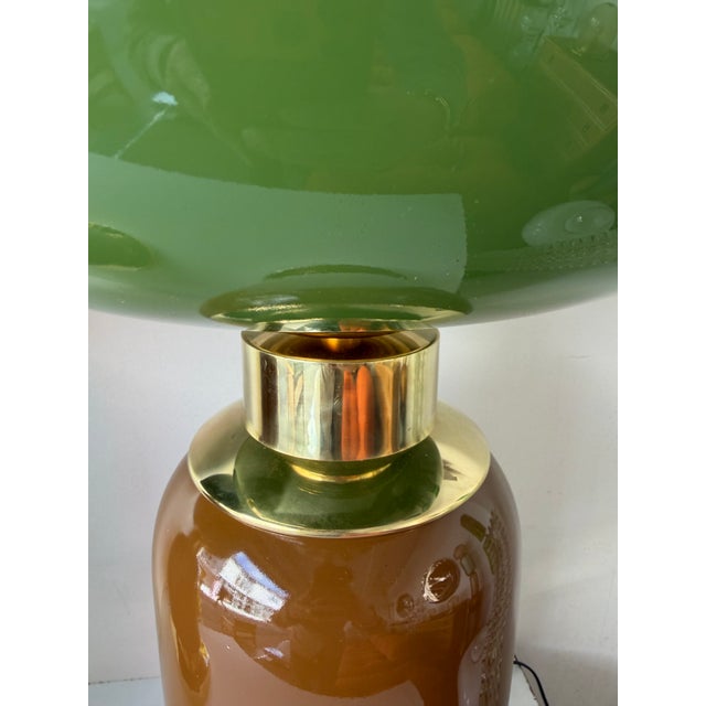 Pair of table or bedside lamps in brass, and brown murano glass with green bulb globe shades. Contemporary work from a...