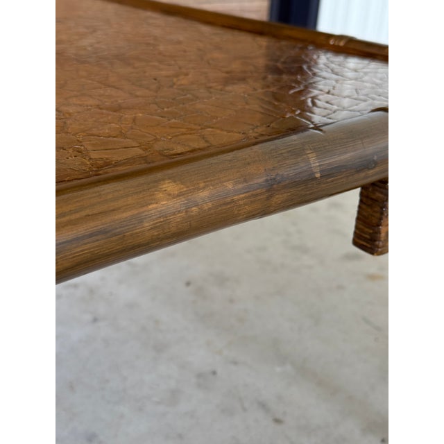 A striking mid-century rattan fretwork coffee table in the manner of John Wisner, showcasing bold geometric lines and an...