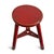 Vintage red painted wooden stool. Round seat with three legs. Aged finish adds character and charm.