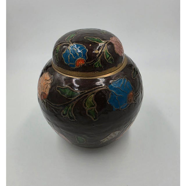 An exquisite vintage Asian cloisonné ginger jar featuring a rich, dark enamel ground decorated with deeply detailed...
