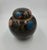 An exquisite vintage Asian cloisonné ginger jar featuring a rich, dark enamel ground decorated with deeply detailed...