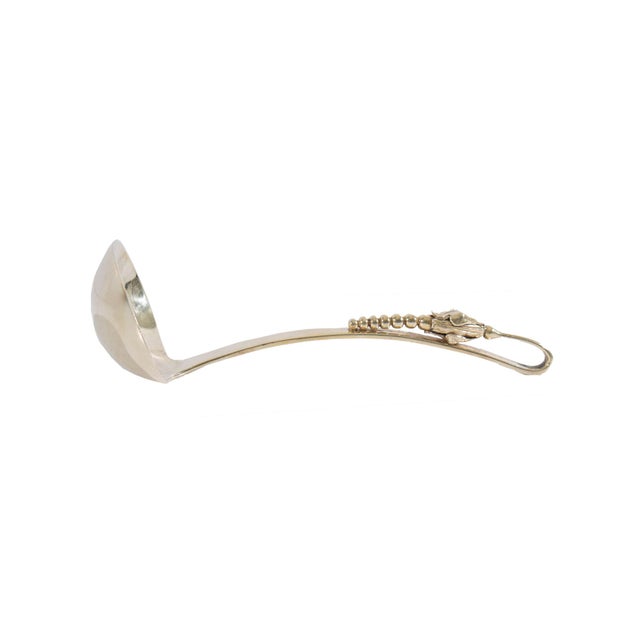 A sterling silver ladle produced by Sanborns. Made in Mexico, this ladle features a blossom accent on the handle. The...