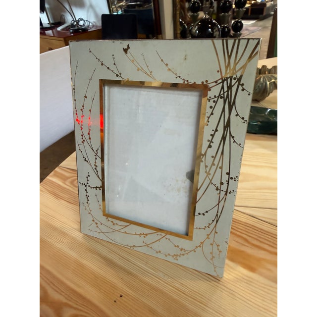 A vintage Italian picture frame featuring an elegant reverse-painted glass panel decorated with delicate gilt botanical...