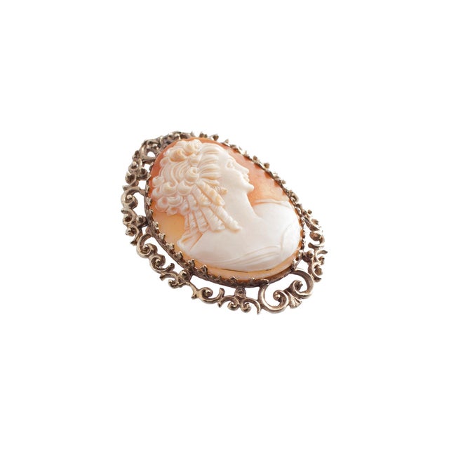 Early 20th Century This brooch is crafted in 14k yellow gold. The piece features a detailed cameo. Adorned with an...