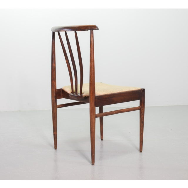 Set of four rosewood spindle back Scandinavian design dining chairs. This solid set features caramel leatherette seatings....