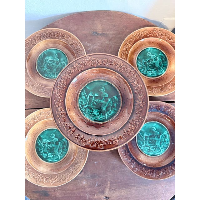 A beautiful set of four plates and 1 cake stand. Late 19th to early 20th century, featuring richly detailed classical...