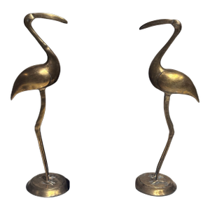 A Pair of Vintage Solid Brass Crane Figurines Standing Gracefully on Round Bases With a Warm, Aged Patina.