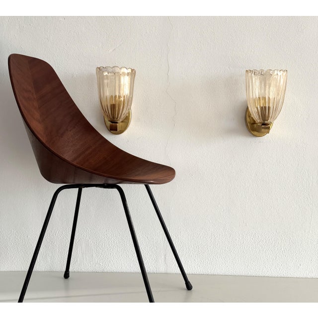 Beautiful set of two gorgeous brass wall lamps made of strong brass base and light amber colored Murano glasses with real...