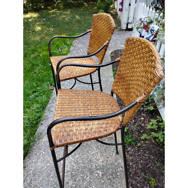 A pair of bar or counter stools. Frame is iron and seat / back is wicker. Wicker is tight and frame is all intact.