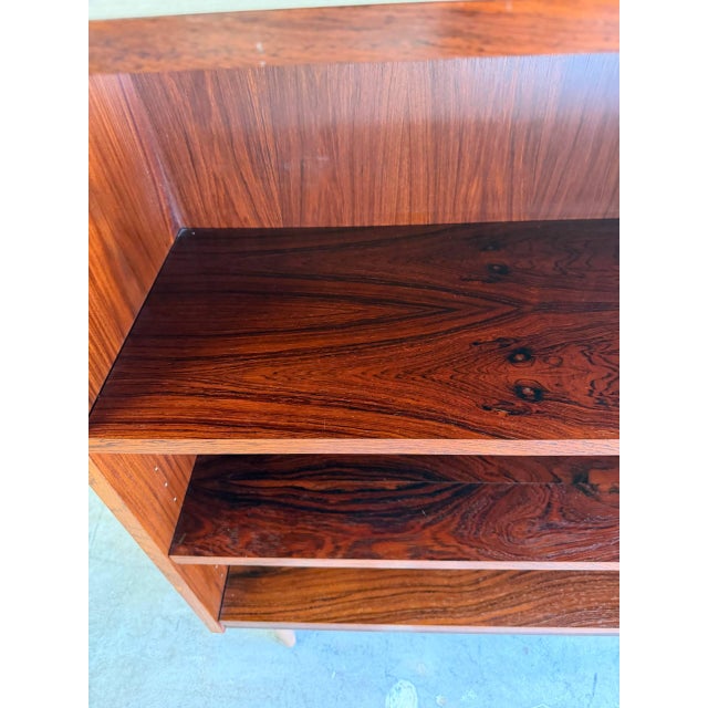 Beautiful Mid Century Modern Danish bookcase crafted in richly grained rosewood, featuring clean Scandinavian lines and...