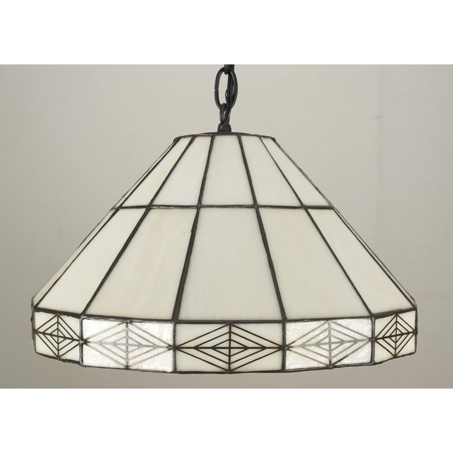 Vintage Arts & Crafts stained glass pendant light. The glass is cream with some tan marbling; there is geometric detailing...