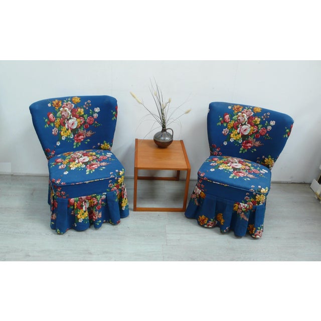 Set of two cocktail chairs from the 1950s with blue floral fabric upholstery and matching ruffle trim at the bottom. from...