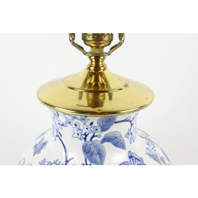 Blue and white ceramic table lamp with flowers and brass accents. This lamp features a ginger jar shape with a classic...