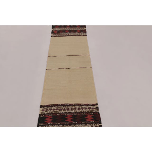 Made with handwoven wool circa 1950-1960, this 2x9 vintage flat-weave runner Kilim is a particularly unique and sought-...