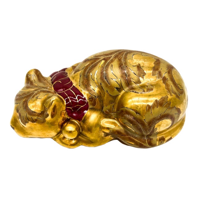 Charming vintage porcelain figurine depicting a peacefully sleeping cat, richly decorated with gold gilt detailing and...