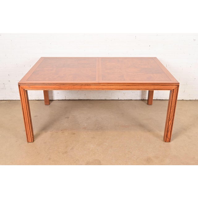 An outstanding Mid-Century Modern Parsons dining table By Henredon USA, Circa 1970s Gorgeous patchwork burl wood top, with...