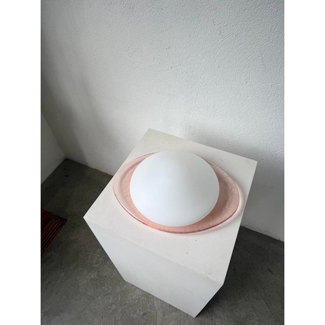 Pink glass wall sconce with a pink opaline shade from the 1970s, by Gamma. We love its oval shape with the slightly...