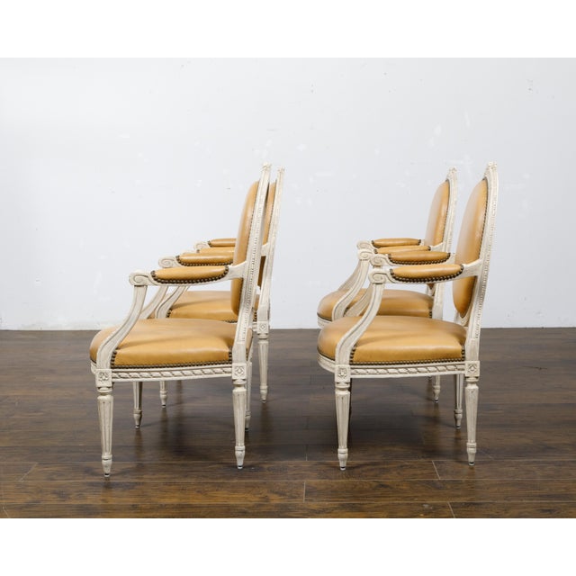 A set of four French Louis XVI style off-white painted oval back armchairs from circa 1900 with carved décor. This set of...