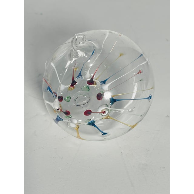 Unique collectible blown glass Christmas ornament ball with multicolor spikes inside.