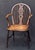 A fine Windsor armchair of elm and ash woods from Georgian era England, featuring a bowed top rail over a pierced splat...