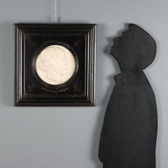 Marble profile depicting John Charles of Bourbon and Braganza. Ebonized wood frame. Engraved signature and date. This...