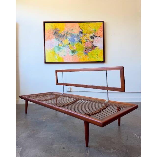 A beautiful example of Danish modern design featuring a sculptural teak frame, tapered legs and exposed metal back...