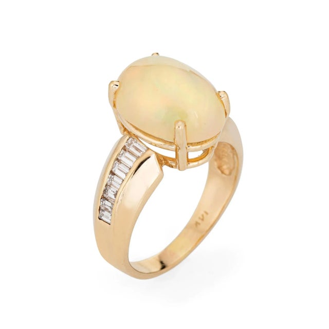 Stylish vintage opal & diamond cocktail ring crafted in 14 karat yellow gold. The natural opal measures 14mm x 10mm...