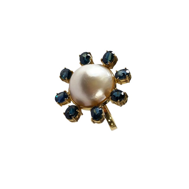 This exquisite 18 karat yellow gold ring features a central, 16.5 mm medium grade Maube pear cut pearl set in a bezel...