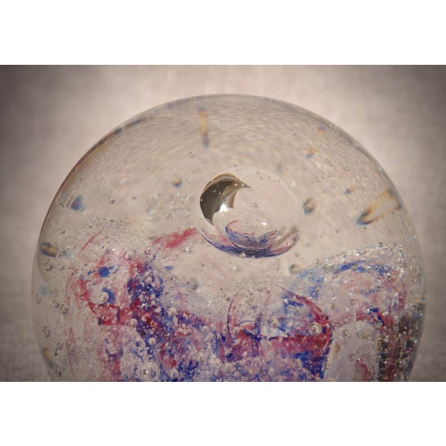 A sphere with internal decorations in various shades of blue, pink, and transparent. A sculpture of the highest quality,...