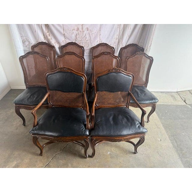 An elegant set of eight French Provincial-style dining chairs, including six side chairs and two armchairs, crafted with...
