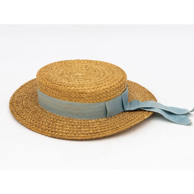 The Ridgemont Make's vintage 1930s boater hat showcases timeless elegance with its natural straw construction. Adorned...