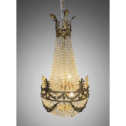 Beautiful French Sac de Pearl chandelier, 20th century, designed in the Empire style with a cast brass basket frame richly...