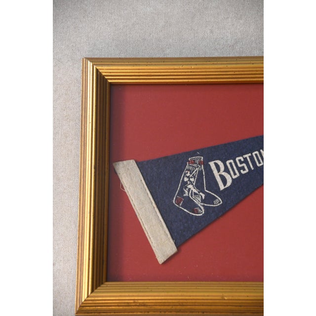 This vintage Boston Red Sox pennant is framed against a new deep red background and finished with a vintage gold-tone...