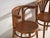 A set of two antique chairs in bentwood, with a curved crest rail over vertical splats and a moulded board seat....