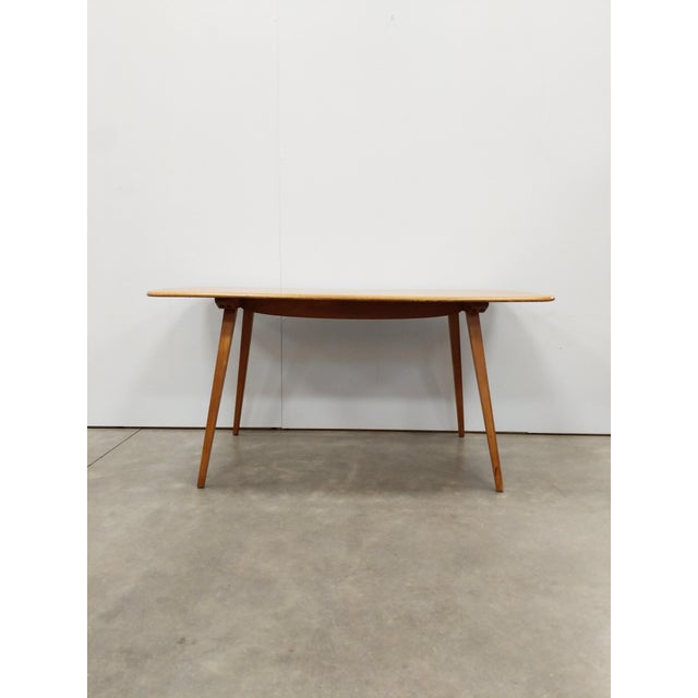 Authentic vintage plank dining table. Model 382 by Ercol (unmarked)/ Solid elm wood top and beech wood legs. This piece is...